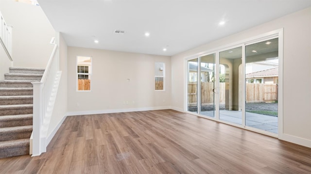 unfurnished living room featuring recessed lighting, wood finished floors, visible vents, and baseboards