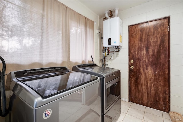 washroom with water heater, light tile patterned floors, and independent washer and dryer