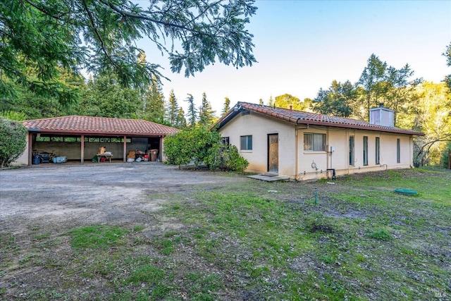 view of home's exterior featuring a lawn and a carport