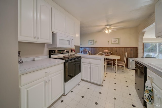 kitchen with electric range, white cabinets, dishwasher, and wooden walls