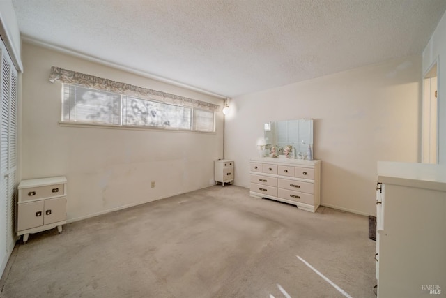 unfurnished bedroom with a textured ceiling and light carpet