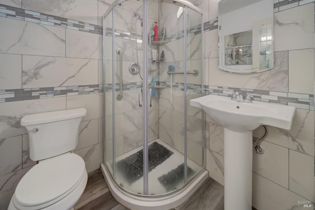 bathroom featuring toilet, tile walls, walk in shower, and wood-type flooring