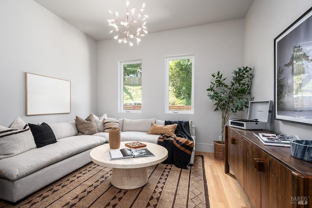 living room with an inviting chandelier and light hardwood / wood-style flooring