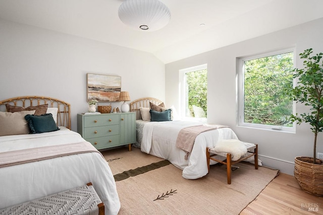 bedroom with lofted ceiling and light hardwood / wood-style floors