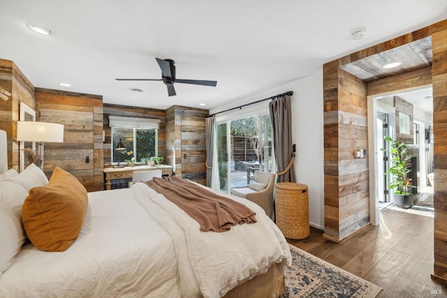 bedroom featuring dark hardwood / wood-style flooring, access to outside, and wood walls