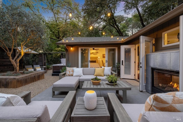 patio terrace at dusk with an outdoor living space with a fireplace