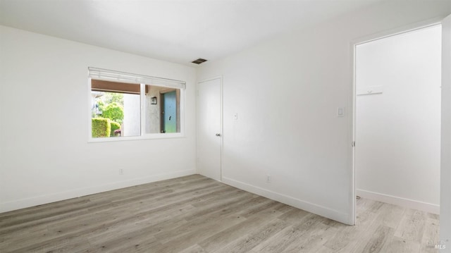 unfurnished room featuring light wood-type flooring, baseboards, and visible vents
