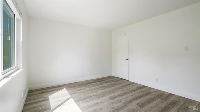 unfurnished room with baseboards and wood finished floors