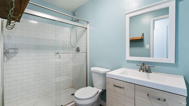 bathroom with toilet, vanity, and a stall shower