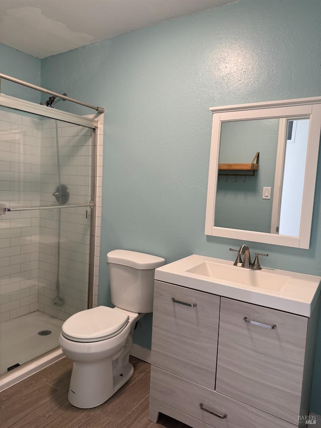 bathroom with toilet, vanity, and an enclosed shower