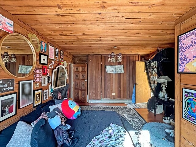 bedroom featuring wooden ceiling, wood finished floors, and wood walls