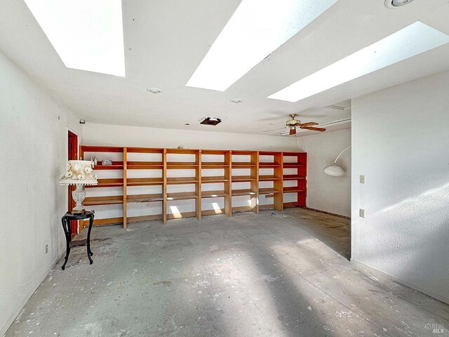 unfurnished room with ceiling fan and unfinished concrete floors