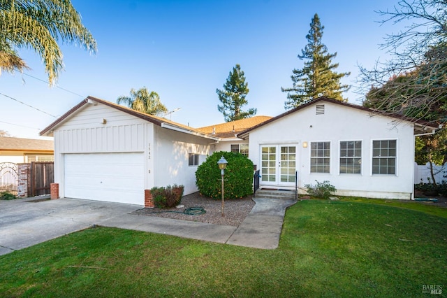 ranch-style house with a garage, french doors, and a front yard