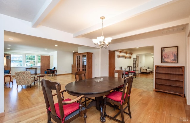 dining room featuring an inviting chandelier, beam ceiling, and light hardwood / wood-style floors