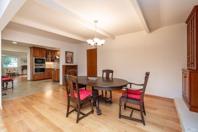 dining room featuring beam ceiling, light hardwood / wood-style flooring, and an inviting chandelier