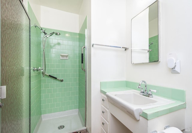 bathroom with a tile shower and vanity