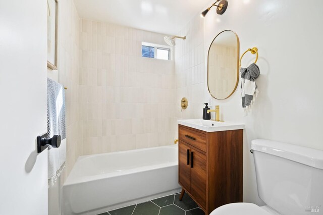 full bathroom featuring toilet, vanity, tile patterned floors, and tiled shower / bath