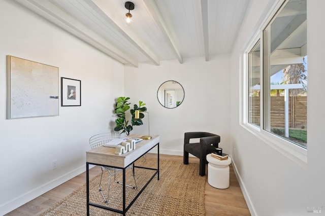 home office with beam ceiling, light wood-style flooring, and baseboards