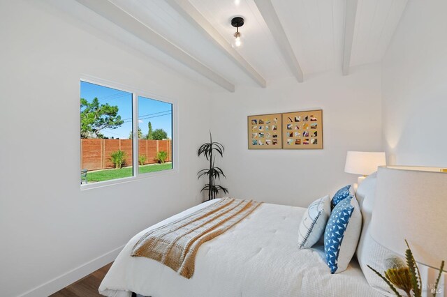 bedroom with beam ceiling and hardwood / wood-style flooring