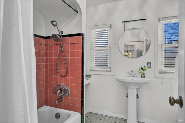 bathroom featuring shower / tub combo and baseboards