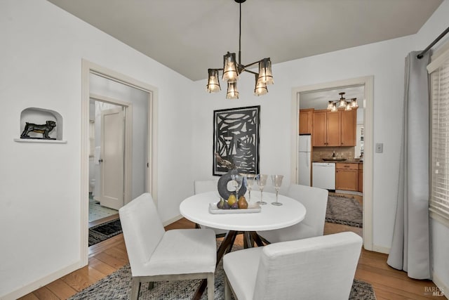 dining room featuring an inviting chandelier and light wood-type flooring