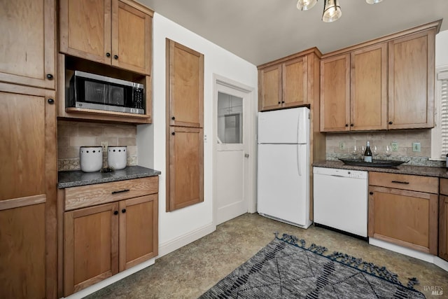 kitchen featuring brown cabinets, white appliances, backsplash, baseboards, and dark countertops