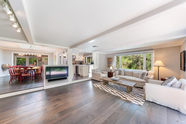 living room featuring dark hardwood / wood-style flooring, a notable chandelier, crown molding, and beamed ceiling