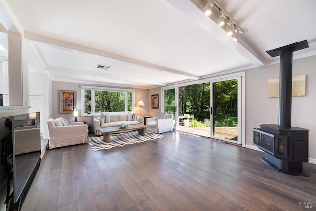 living room with beamed ceiling, dark wood-type flooring, and a wood stove