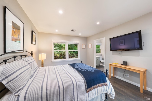 bedroom with ensuite bath and dark hardwood / wood-style flooring