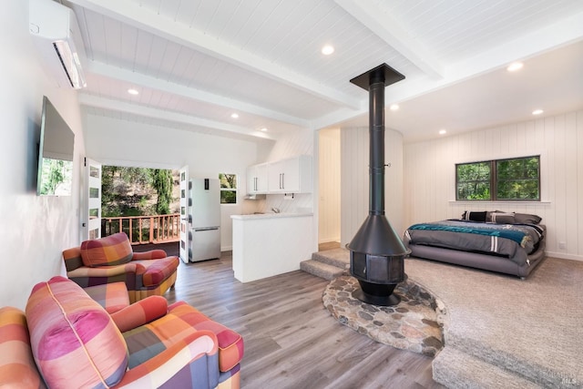 living room featuring an AC wall unit, wooden ceiling, beamed ceiling, and hardwood / wood-style floors