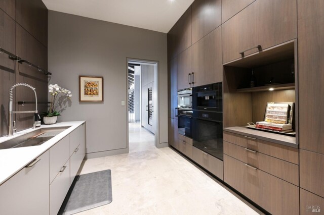 kitchen featuring a kitchen island, a healthy amount of sunlight, light stone counters, and beamed ceiling