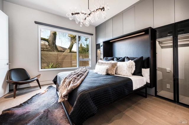 bedroom featuring a chandelier and light hardwood / wood-style flooring