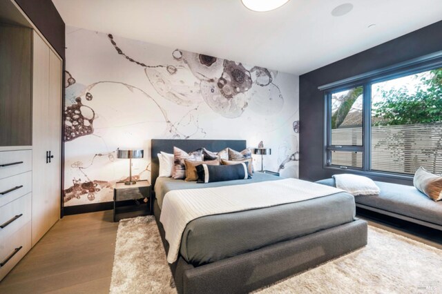 bedroom with light wood-type flooring and a notable chandelier