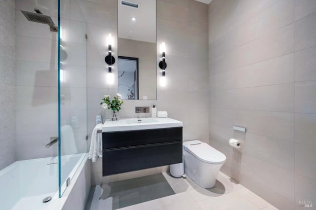 full bathroom with tile patterned flooring, toilet, vanity, tile walls, and shower / bathtub combination