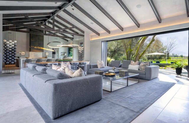 living room with beam ceiling and high vaulted ceiling