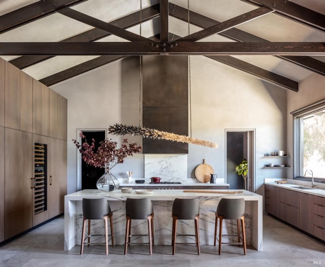 kitchen with sink, high vaulted ceiling, and a kitchen breakfast bar