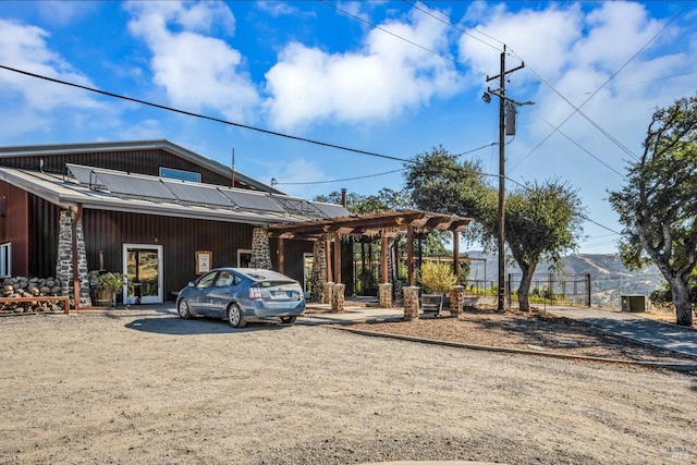 500 Old Long Valley Rd, Clearlake Oaks, CA 95423 - view of front facade with driveway, metal roof, roof mounted solar panels, and a pergola