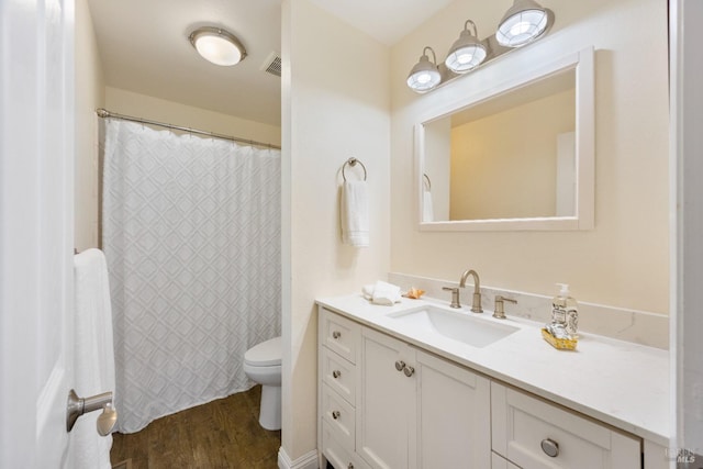 bathroom with toilet, vanity, and hardwood / wood-style flooring