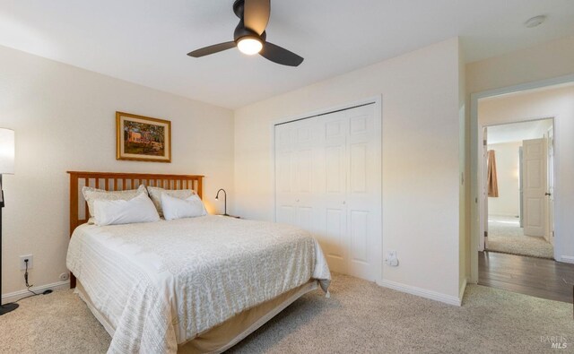 carpeted bedroom featuring a closet and ceiling fan