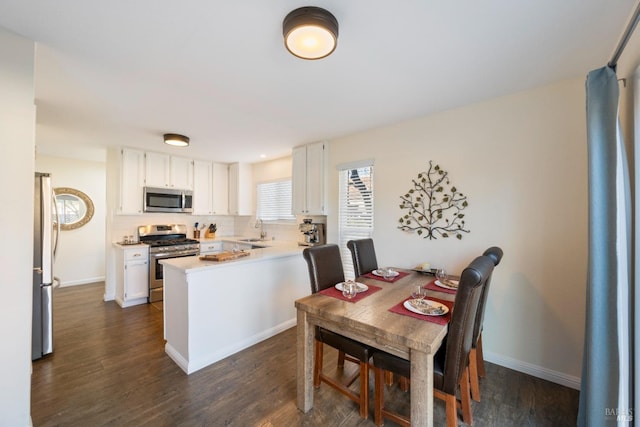 kitchen featuring sink, kitchen peninsula, white cabinets, and stainless steel appliances