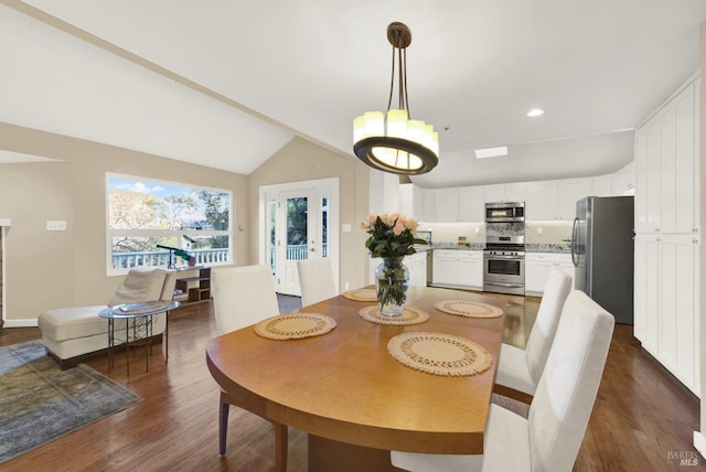 dining space with vaulted ceiling and dark hardwood / wood-style flooring