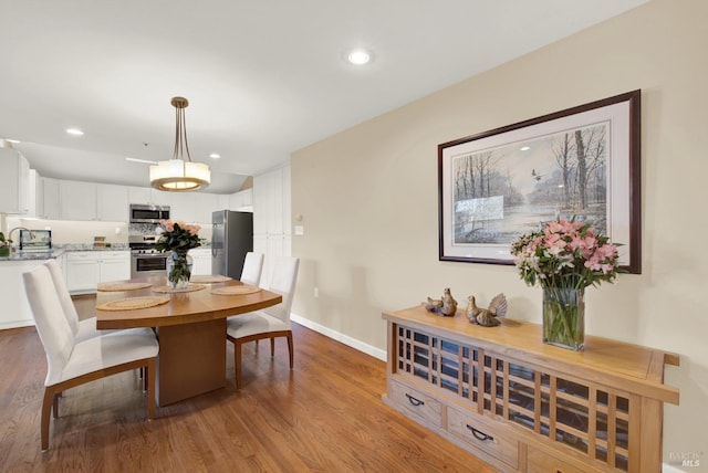 dining area featuring sink and light hardwood / wood-style flooring