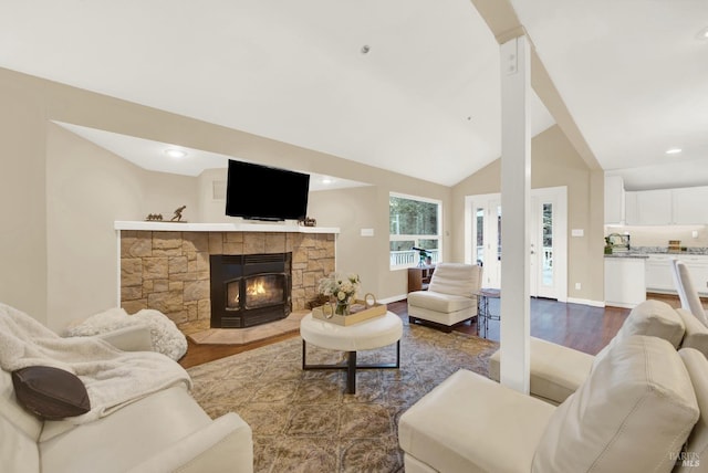 living room featuring lofted ceiling, a fireplace, and dark hardwood / wood-style flooring