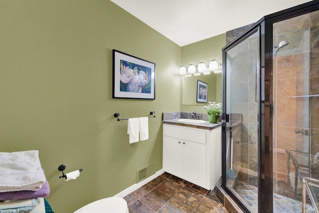 bathroom with vanity, toilet, and a shower with shower door