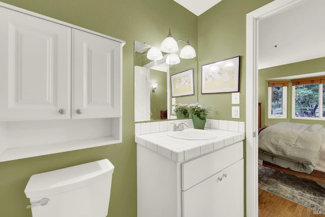 bathroom featuring vanity, hardwood / wood-style floors, and toilet