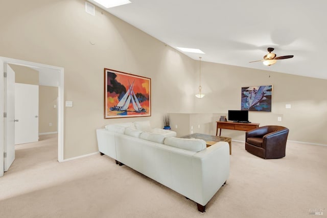 carpeted living room featuring ceiling fan and lofted ceiling with skylight