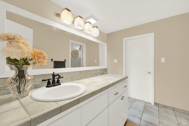 bathroom featuring tile patterned flooring, vanity, and backsplash