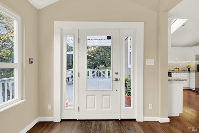 entrance foyer with vaulted ceiling and dark hardwood / wood-style floors