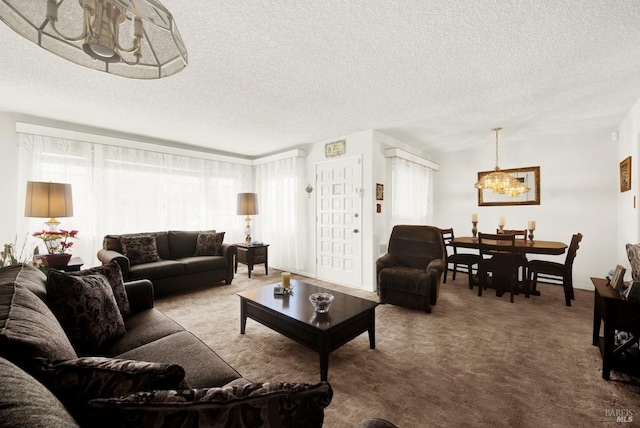 living room featuring carpet, a notable chandelier, and a textured ceiling