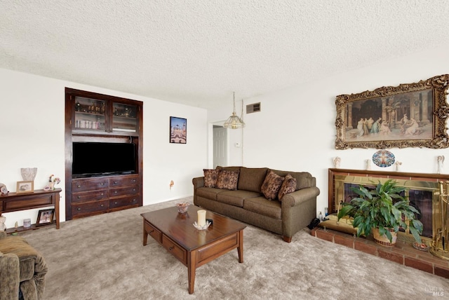 living room with a glass covered fireplace, visible vents, light carpet, and a textured ceiling